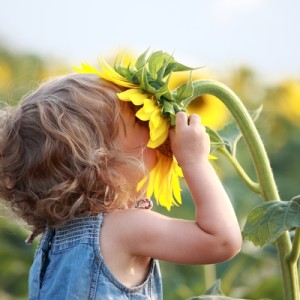 child smelling flower